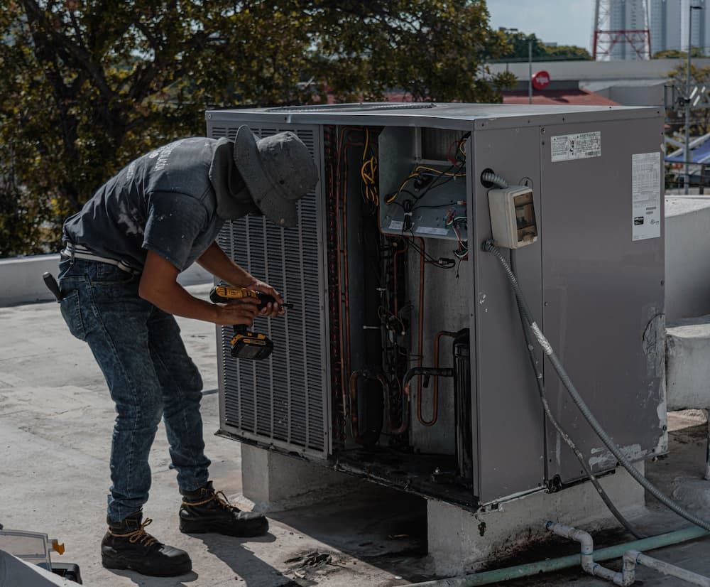 Técnico realizando el mantenimiento de una unidad de climatización en cubierta