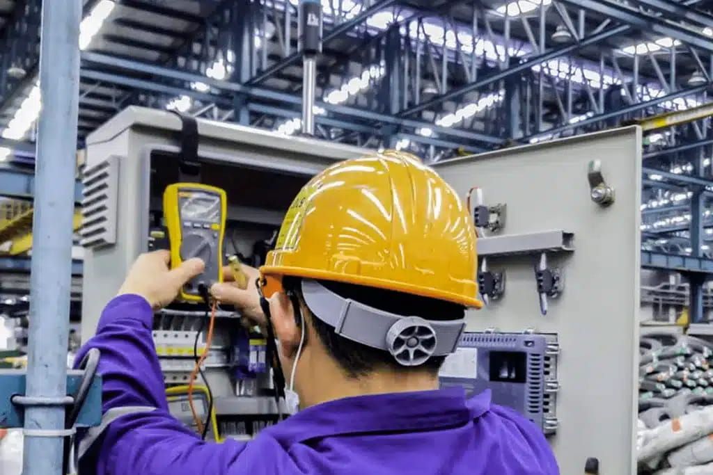 Técnico midiendo un cuadro eléctrico industrial con un multímetro